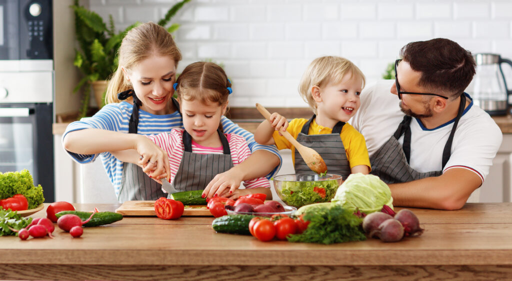 appy family with child preparing vegetable salad